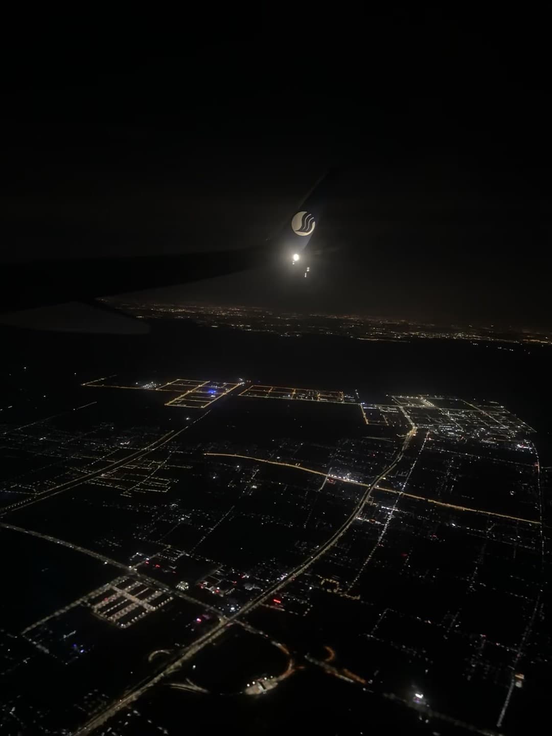 飞机舷窗拍的夜景，机翼上那个小标志在发光…今晚降落前的温柔时刻封面图