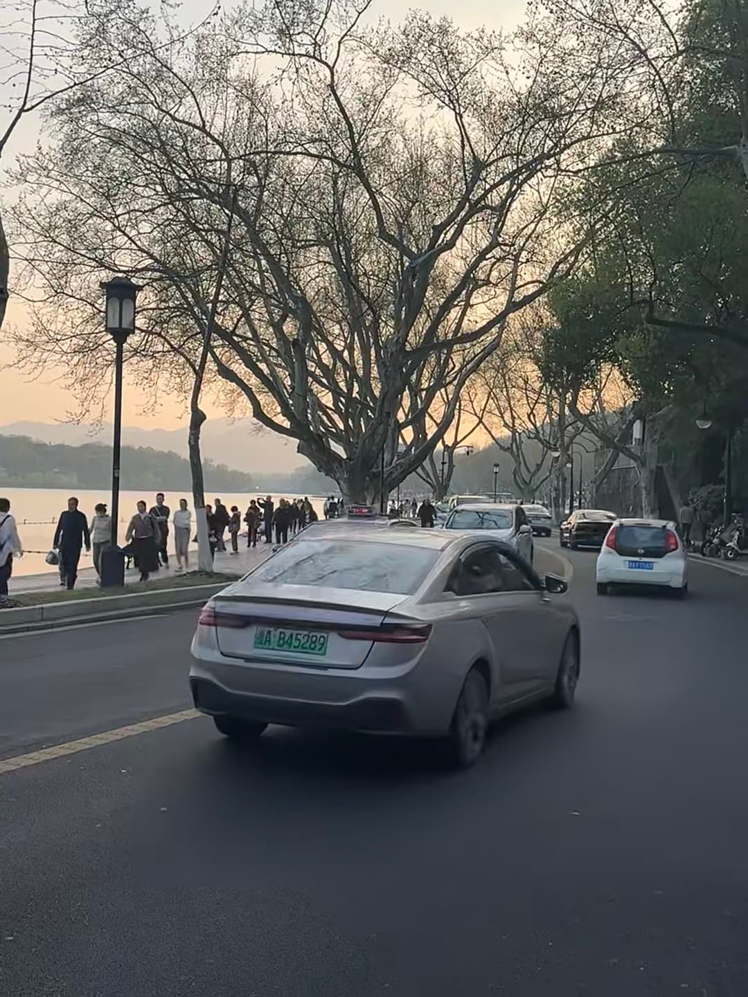 傍晚湖边的银车,车牌B45289,像在拍电影封面图