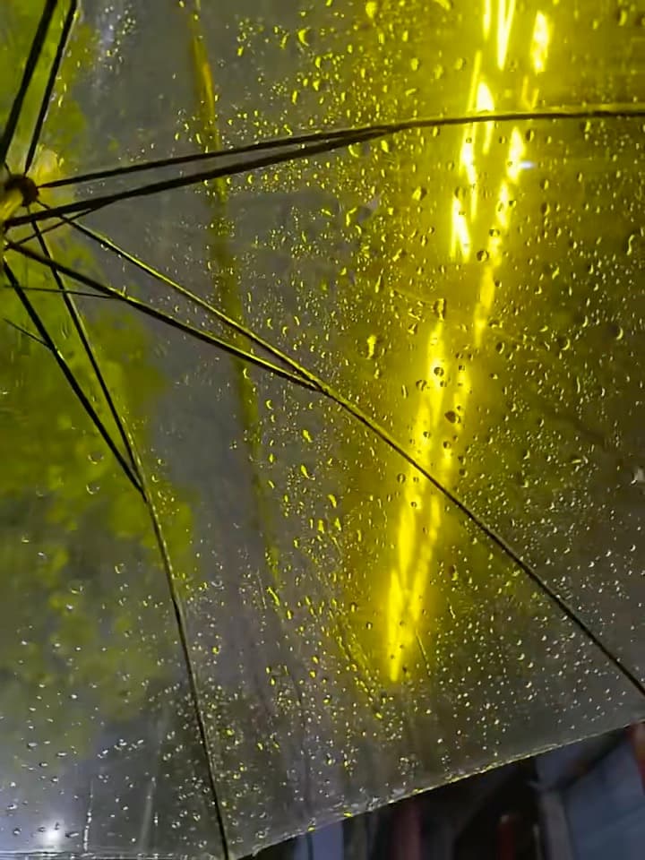雨夜撑伞回住处,黄光在伞面晃成一道光瀑封面图