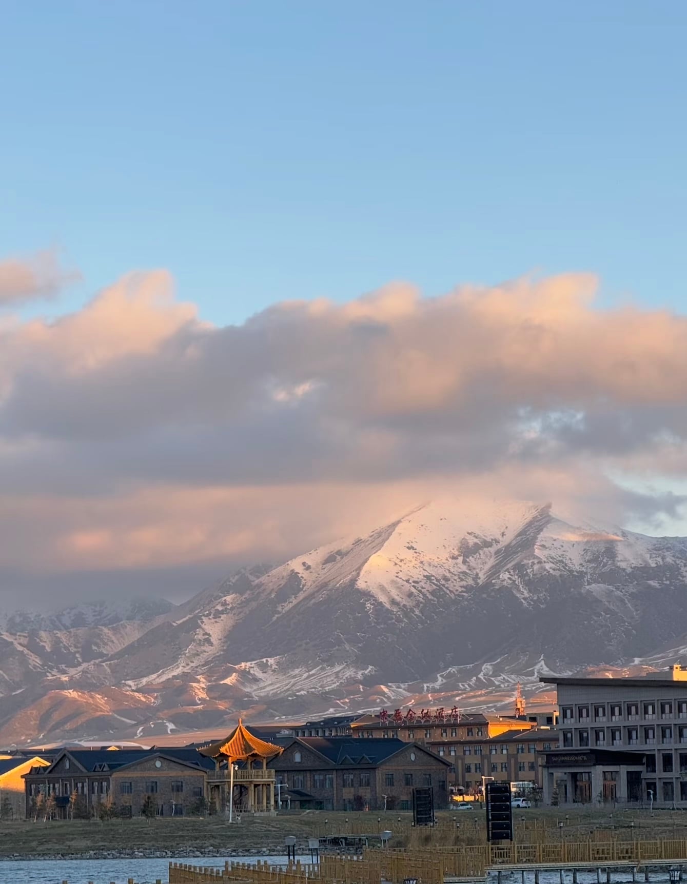 雪峰在云层里偷看夕阳，连酒店的灯笼都染了金边～