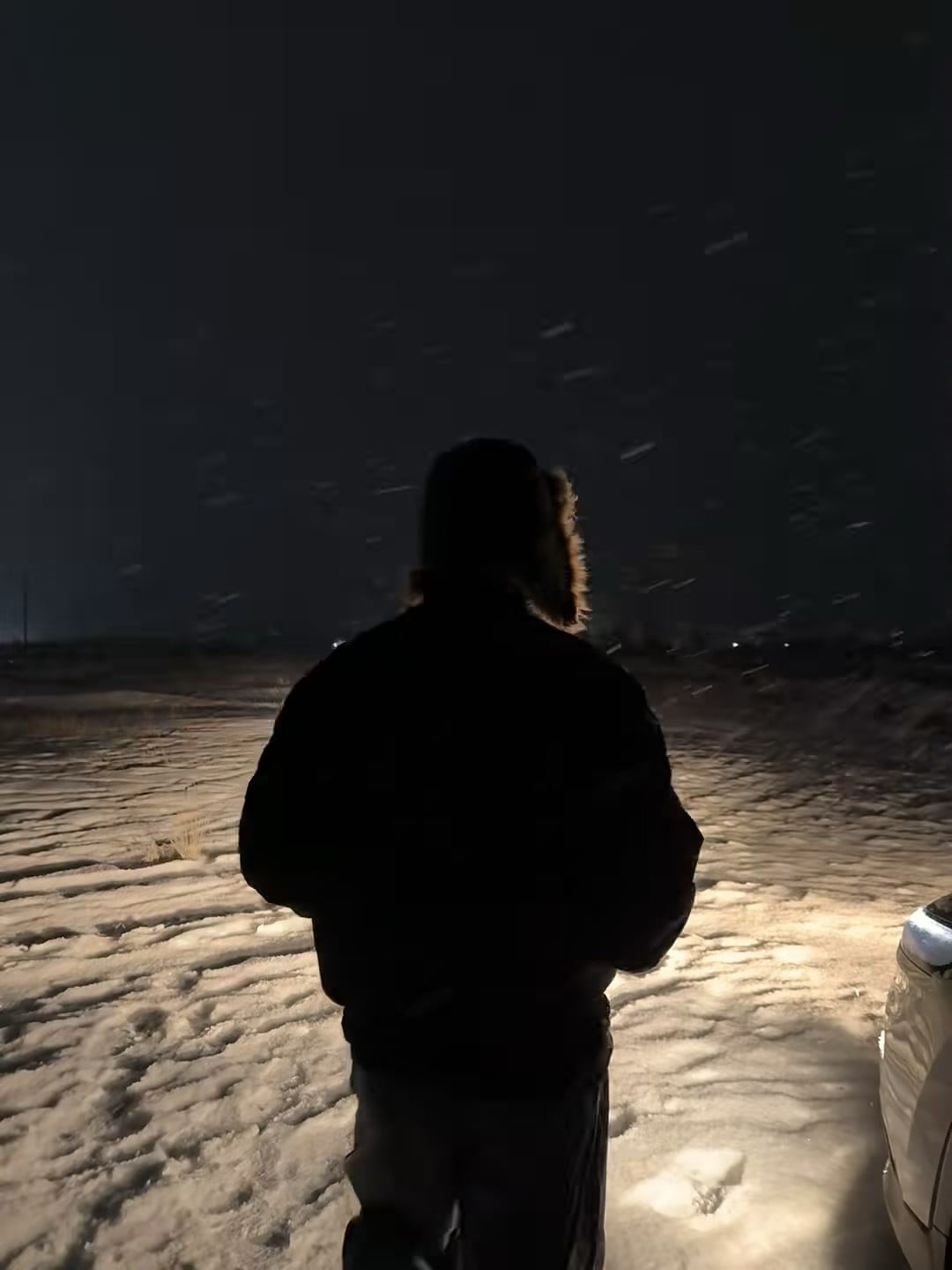 雪夜停车场，车灯一照，人影和雪花都成了电影感滤镜