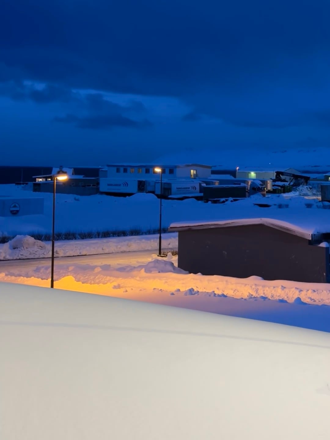 冬夜路灯下，雪地里踩出的暖黄脚印