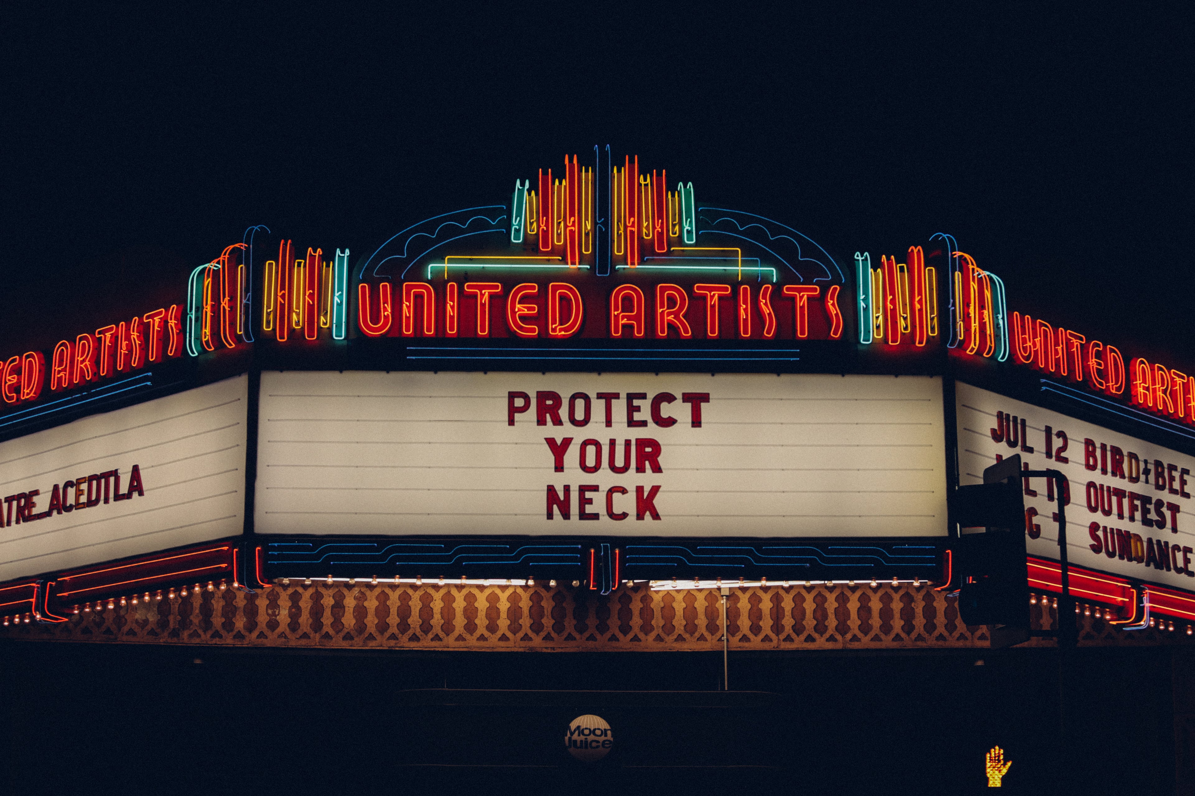 深夜路过联合艺术家剧院，霓虹在黑夜里突然说：Protect Your Neck