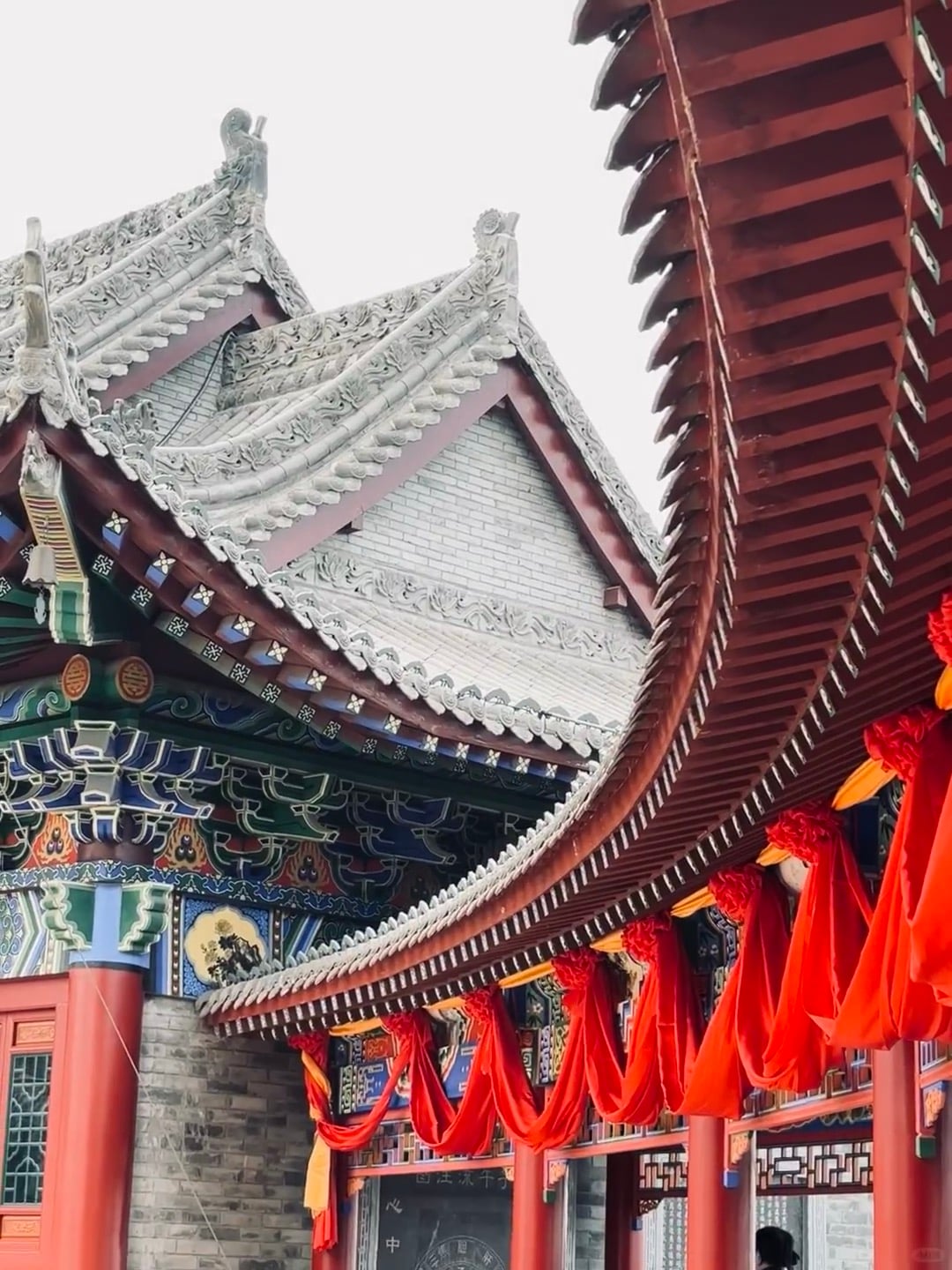 路过老城巷子，突然被这飞檐震住——红绸子飘着像在呼吸