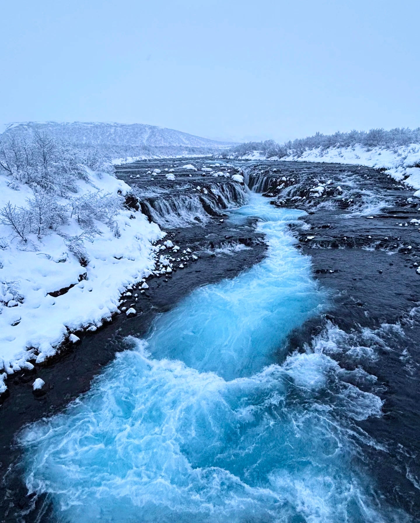 雪天路过Hvítá河，冰蓝水流像打翻了整片极光